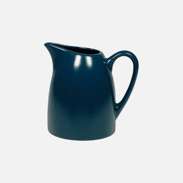 Blue ceramic pitcher on a white background.