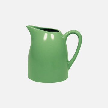 Green ceramic pitcher on a white background.