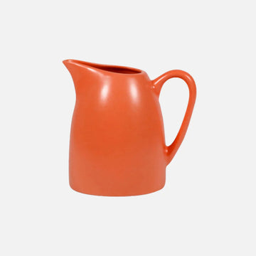 An orange ceramic pitcher on a white background.
