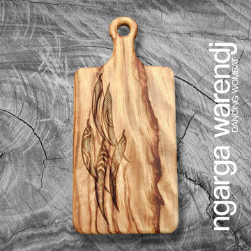 A wooden board with a paddle and etched with five gum leaves.