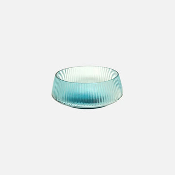 Turquoise glass bowl with ribbed texture on a light gray background.