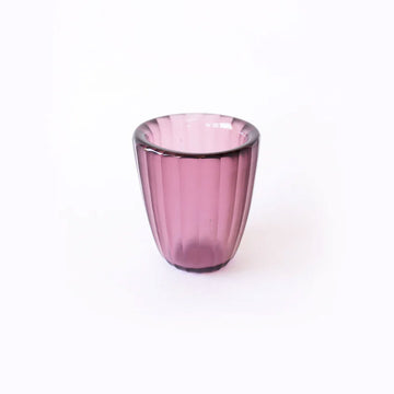 Pink glass beaker on a white background.