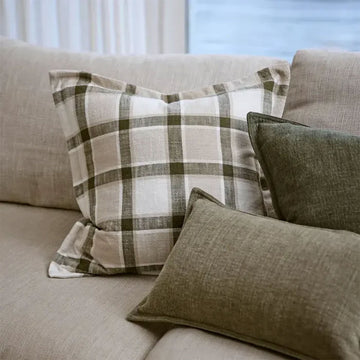 Plaid pillow with green and beige pattern on a white background.