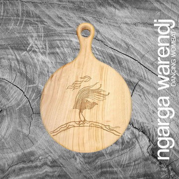 A wooden round board with a paddle and etched with a design of a lyrebird.