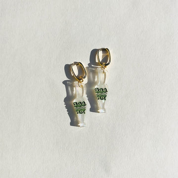 A pair of resin earrings shaped like vases attached to gold hoops.
