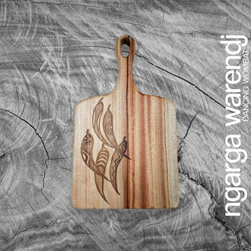 A square wooden board with a paddle and etched with a design of five gum leaves.