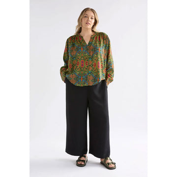 A women's long sleeve shirt with a green, orange and blue pattern.