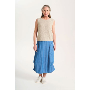 A skirt in a light denim blue with side pockets against a white background.