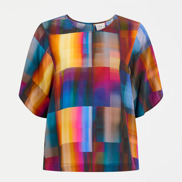Colorful abstract patterned blouse on a white background.