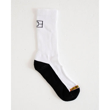 A white sock with a black sole and an outline of the Aboriginal flag on the back.