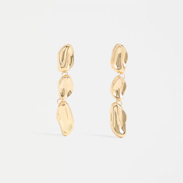 Gold drop earrings on a light gray background.