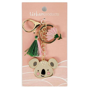 A keyring with a koala charm, tassel and flower charm attached to a pink card with the text 'Urban Products' along the top.