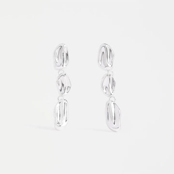 A pair of silver drop earrings with three round pieces linked together.