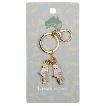 A keyring with a charm of a cockatoo and a Major Mitchell cockatoo attached to a card with the text 'Urban Products' on the bottom.