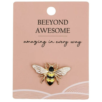 A bee shaped enamel pin attached to a pink card with the text 'Beeyong Awesome Amazing in every way' along the top.