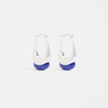 Pair of hoop earrings with silver tops and blue bottoms on a light gray background.