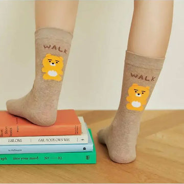 Pair of beige socks with cartoon character and 'WALK' text on a white background.