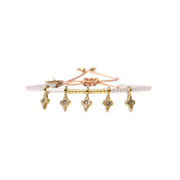 A beaded gold and white bracelet with gold star shaped charms hanging.