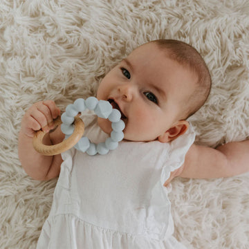 A teething toy featuring a silicone and wooden ring linked together.