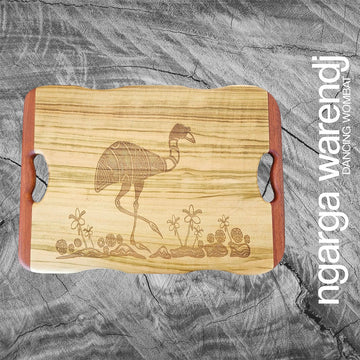 A wooden board with an etch drawing of an emu and plants.