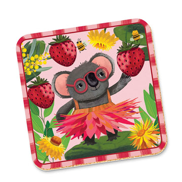 A cork coaster illustrated with a koala wearing a pink grass skirt and surrounded by strawberries and flowers.