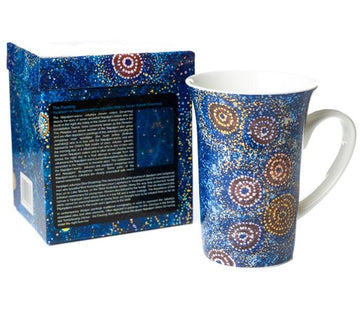 Fine Bone China mug, height 12.5cm. Blue background with red, white, and orange dot art circles.  Artwork by Warlukurlangu Artist Alma Granites. Glossy white glaze inside. Matching gift box.