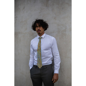 A yellow tie with black horizontal lines and three blue vertical lines featuring artwork by Wokka Taylor.