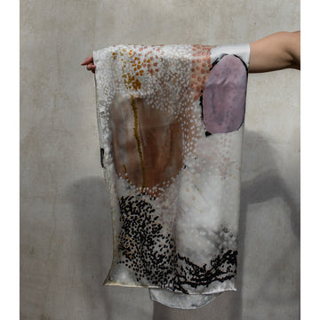 A silk scarf is laid out featuring artwork by Mulyatingki Marney with pink circles and red, blue and orange spots on a white background.