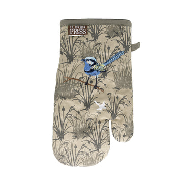An oven mitt in light brown with an embroidered blue wren and printed shrubs.