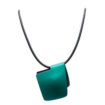 A pendant made from anodized black and emerald green stainless steel in the shape of a folded over square on a black cord.