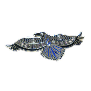 An enamel pin the shape of an illustrated crow in blue and black.