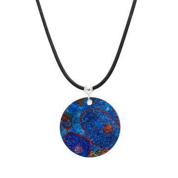 A round pendant printed with artwork by Alma Granites in blue on a black cord.