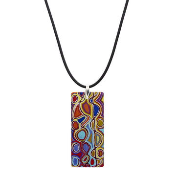 A rectangle pendant printed with artwork by Judy Watson on a black cord.