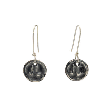 A pair of drop earrings in silver with a kangaroo footprint embossed on a circle.