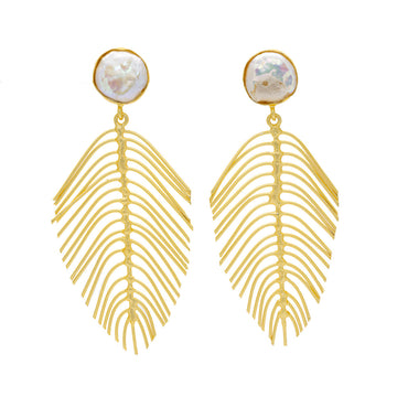 A pair of large gold earrings in the shape of a fern leaf with a iridescent round stone at the top.