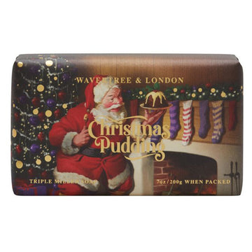 Christmas Pudding soap packaging featuring an image of Santa holding Christmas pudding in front of a fireplace and Christmas tree.