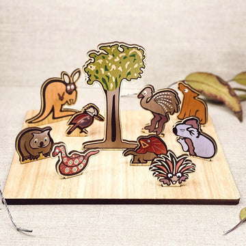 Pop Up Australian Animals puzzle shown with nine wooden animals standing around a tree. The animals include a kangaroo, a kookaburra, a snake and an echidna.