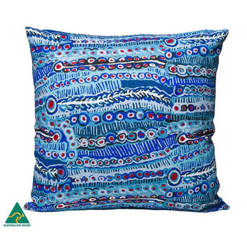 A cushion with a blue cover featuring artwork by Murdie Morris.