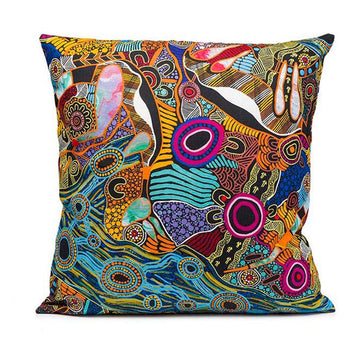 A cushion printed with artwork by Justin Butler in blue, orange and browns.