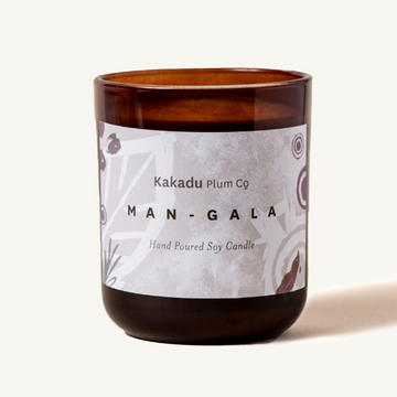 Candle Mangala by Kakadu Plum Co. Amber jar with a white Label.