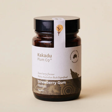 Amber coloured glass jar, black plastic lid, label with indigenous motif. Kakadu Plum Co, Australian Sustainable, Strawberry Gum flakes, in printed type on label. Logo printed on tamper proof tab.