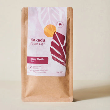 A natural tan pouch depicting a photo of a maroon leaf, white leaf and an orange berry. Text is in maroon and white stating "Kakadu Plum Co".