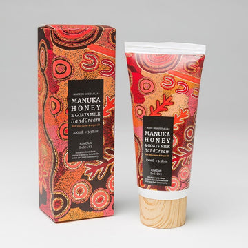 Manuka Honey hand cream100ml, plastic tube has wooden lid, giftbox. Orange, red, white dot art on a black background, artwork by Warlukurlangu Artist Theo Hudson. White text, Australian Made.