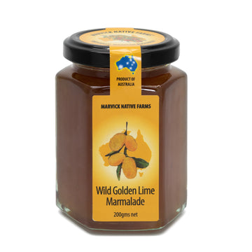 A clear glass jar of wild golden lime marmalade with a yellow label and black lid.
