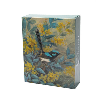 Four greeting cards are displayed overlapping each other on the left. The cards feature birds sitting in amongst leaves and flowers in a tree. On the right is a picture of the box which has an image of a blue and black bird sitting on a brand surrounded by yellow wattle.
