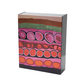 Four greeting cards are pictured on the left overlapping each other. They feature colourful Indigenous artwork by Mornington Island Art. The box is pictured on the right and has artwork in the colours of pink, green and red.