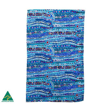 A tea towel is laying flat featuring artwork in blue with red dots by Murdie Morris.