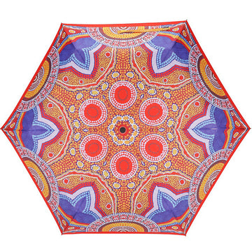 An open umbrella featuring artwork by Norman Cox in blue, red and orange.