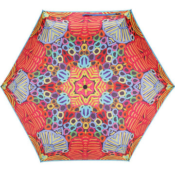 An open umbrella featuring artwork by Betty Mbitjana in red, blue and yellow.
