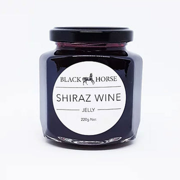 A clear jar with a black lid and white product label. The label says 'Black Horse Shiraz Wine Jelly' with an image of a horse. The jelly can be seen through the jar.